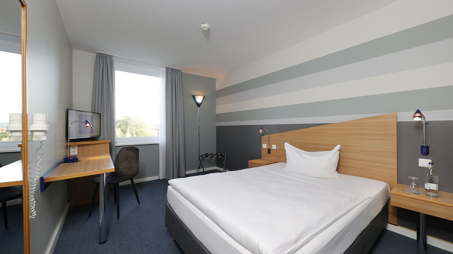 Willkommen im Median Hotel Hannover Messe! Gemütliches Hotelzimmer mit Einzelbett, Schreibtisch und Fenster mit Vorhängen