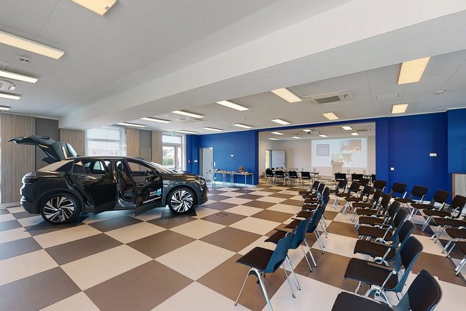 Median Hotel Hannover Lehrte Conference room with rows of chairs and a black car with open doors