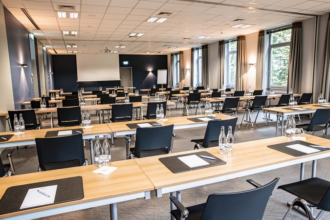 Median Hotel Hannover Lehrte Conference room with tables, chairs, water bottles, and writing materials