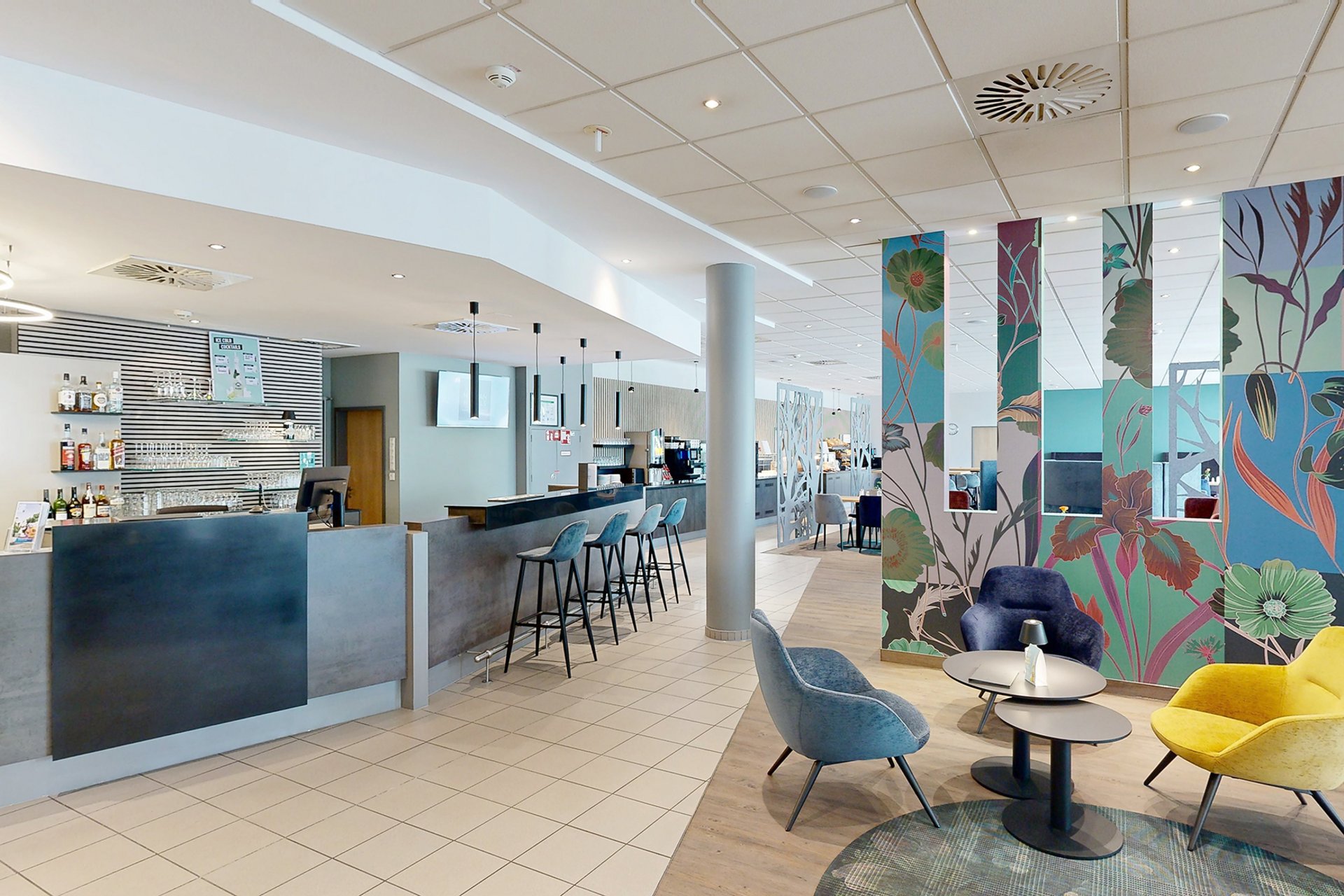 Unser Hotel an der Messe: die Bildergalerie Moderner Hotelbarbereich mit Sitzgelegenheiten und bunten Wänden