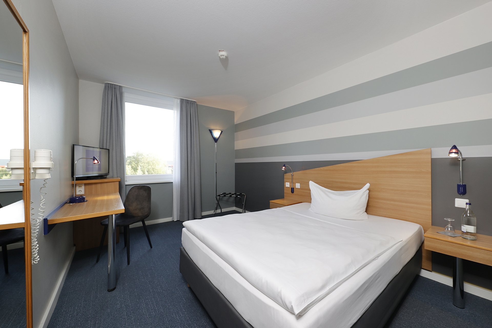 Unser Hotel an der Messe: die Bildergalerie Gemütliches Hotelzimmer mit Einzelbett, Schreibtisch und Fenster mit Vorhängen