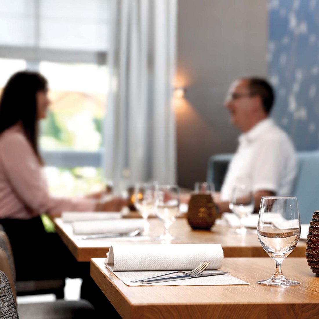 Median Hotels: job openings in Hanover and Lehrte Two people sitting and talking at a restaurant table.