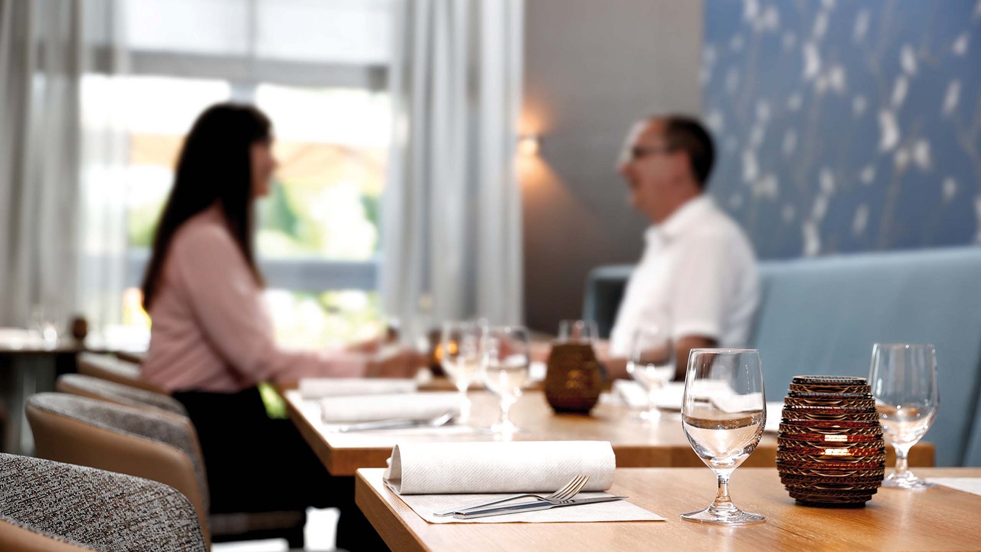 Just outside Hanover: your restaurants in Lehrte Two people sitting and talking at a restaurant table.