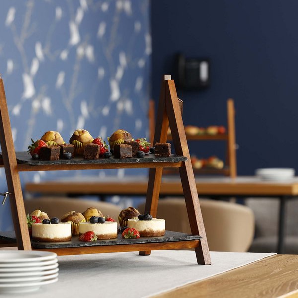 Median Hotel Hannover Lehrte Multi-tier wooden stand with muffins, mini cheesecakes, and berries on table