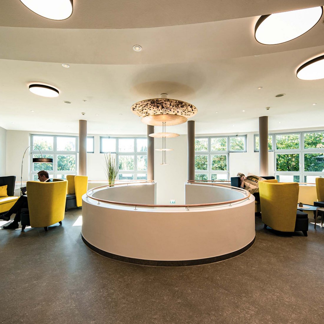 Median Hotels: job openings in Hanover and Lehrte Modern lounge with yellow chairs and large windows on a bright day