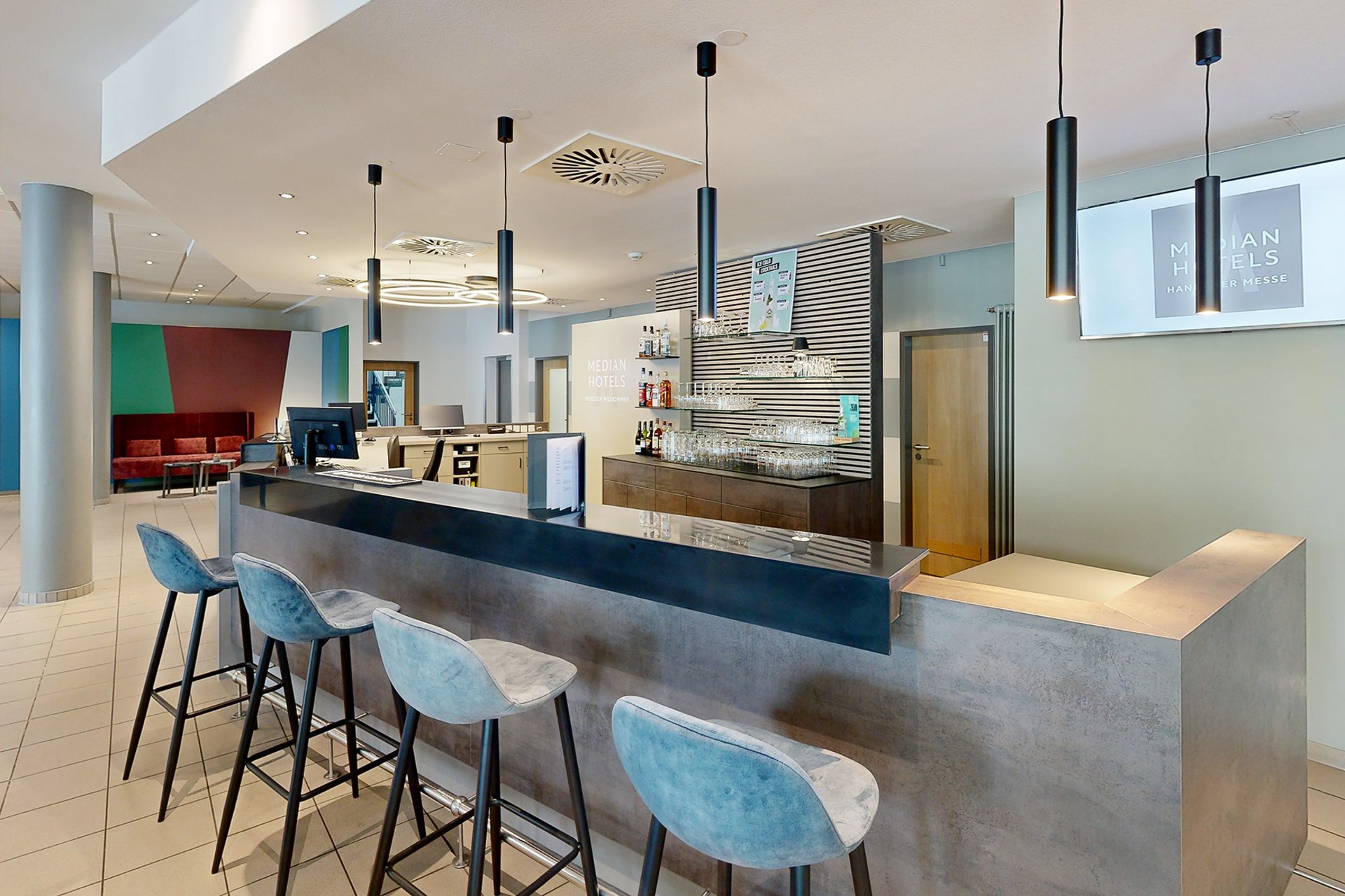 Unser Hotel an der Messe: die Bildergalerie Moderne Hotelbar mit bequemen Barhockern und stilvoller Beleuchtung