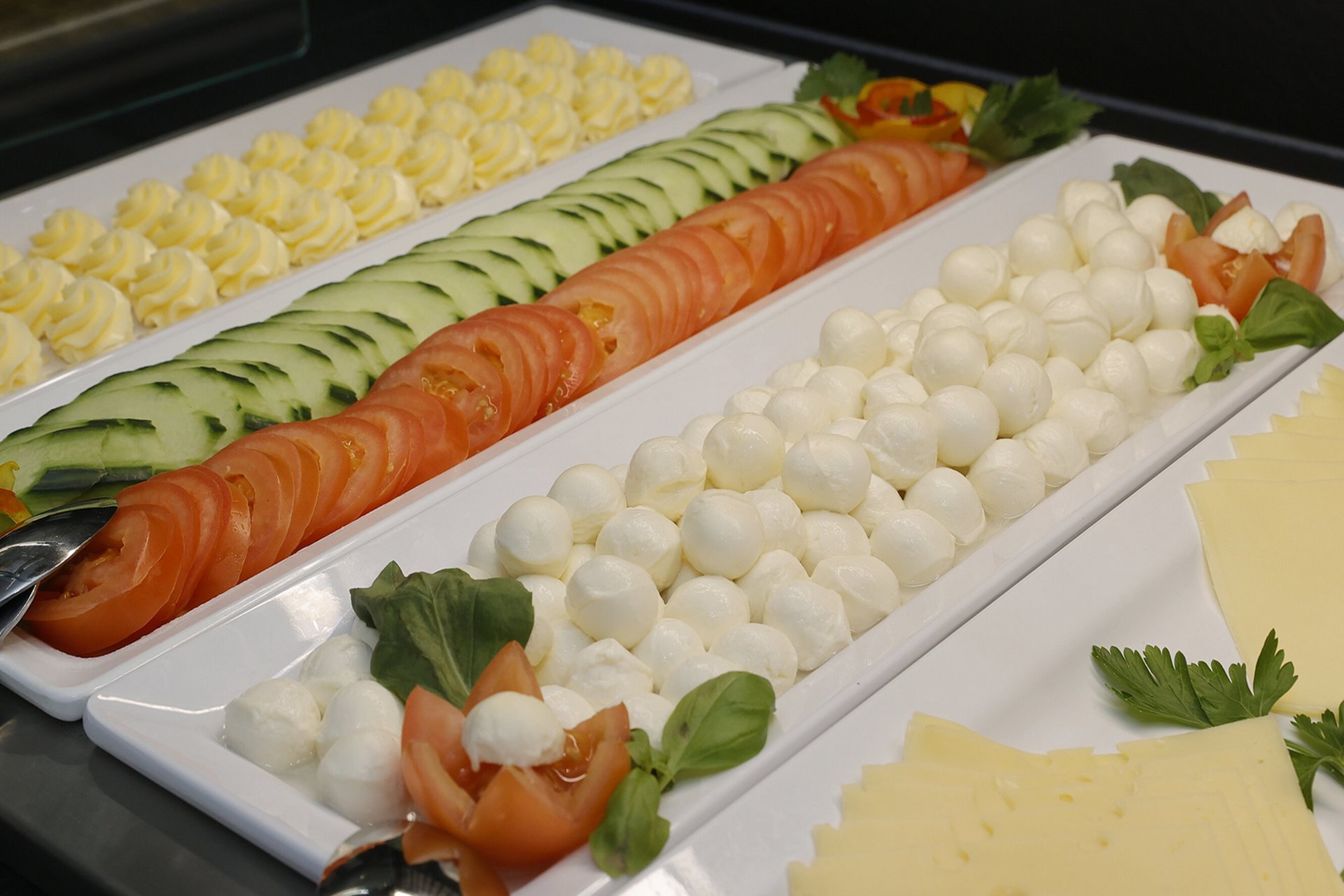 Unser Hotel an der Messe: die Bildergalerie Platten mit Mozzarella, Tomaten, Gurken, Butter und Käse auf einem Buffet