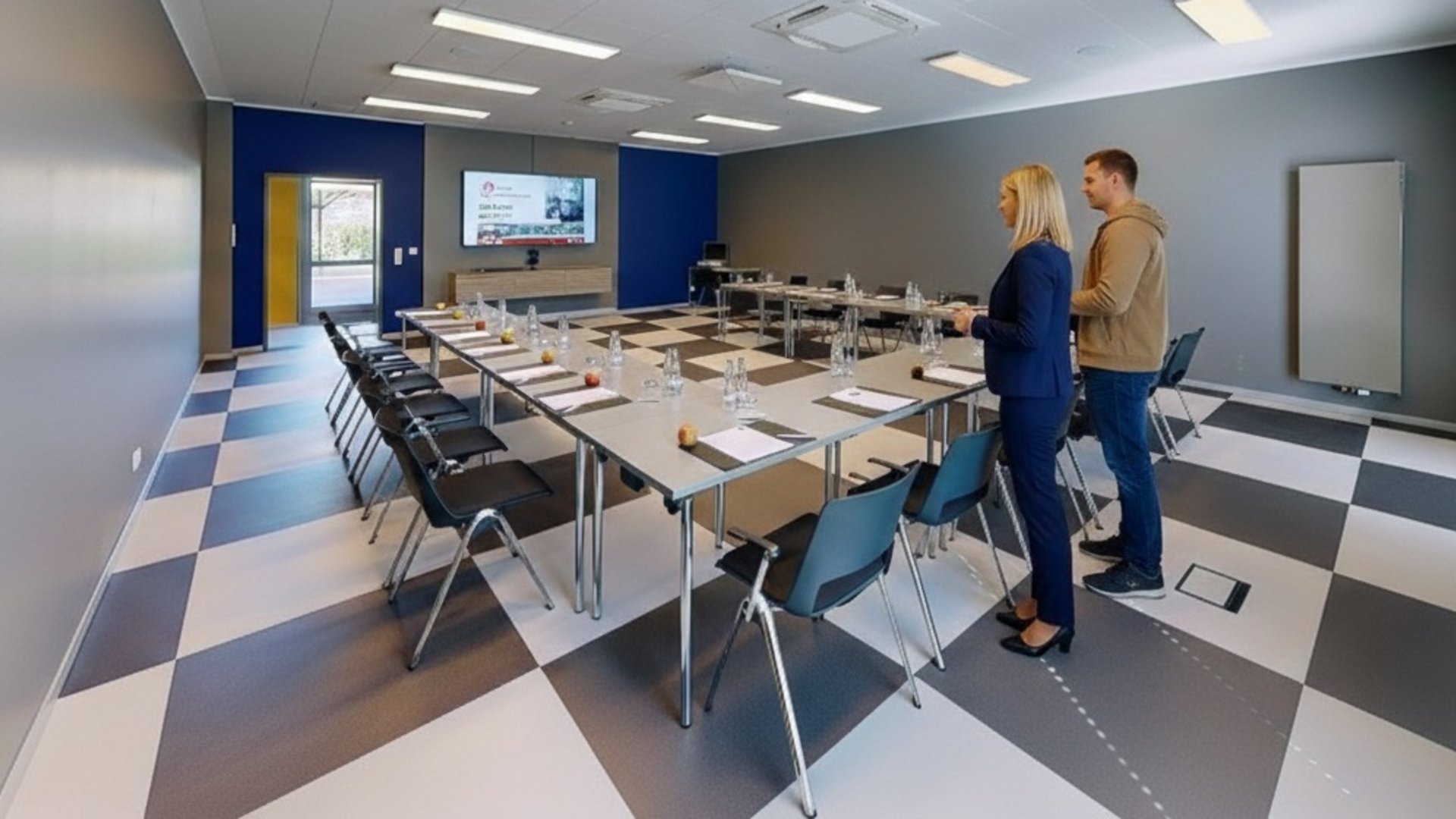 Median Hotel Hannover Lehrte Conference room with U-shaped table set for meeting, two people standing
