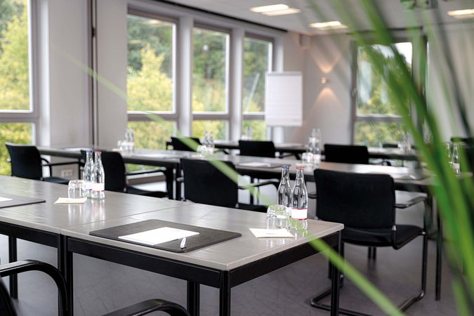 Median Hotel Hannover Lehrte Modern conference room with tables, chairs, water bottles, and notepads
