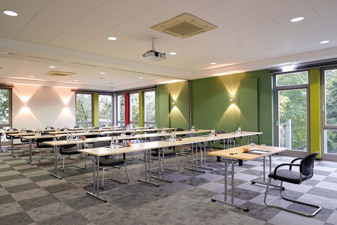 Median Hotel Hannover Lehrte Bright seminar room with tables, chairs, water bottles and apples
